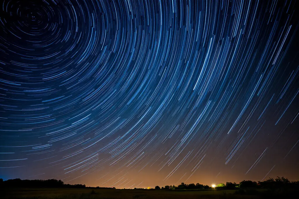 Ein langzeitbelichtetes Foto des Nachthimmels das die hohe Anzahl künstlicher Satelliten um die Erde durch ihre Lichtspuren zeigt