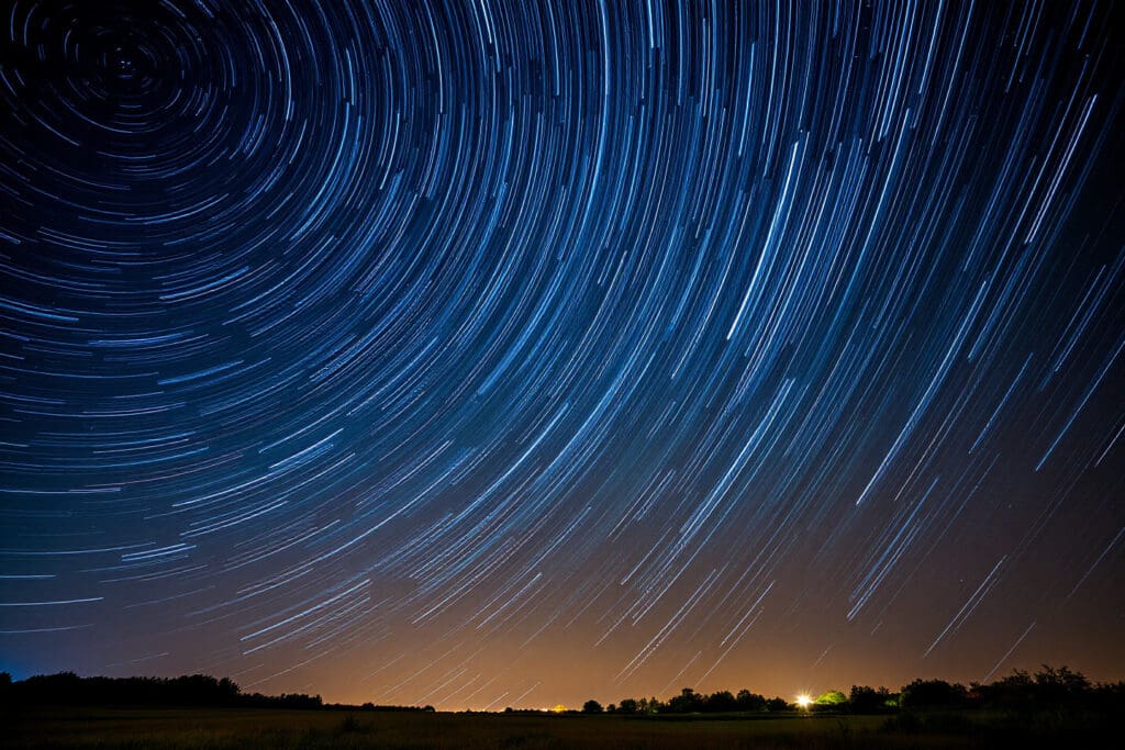 Ein langzeitbelichtetes Foto des Nachthimmels das die hohe Anzahl künstlicher Satelliten um die Erde durch ihre Lichtspuren zeigt